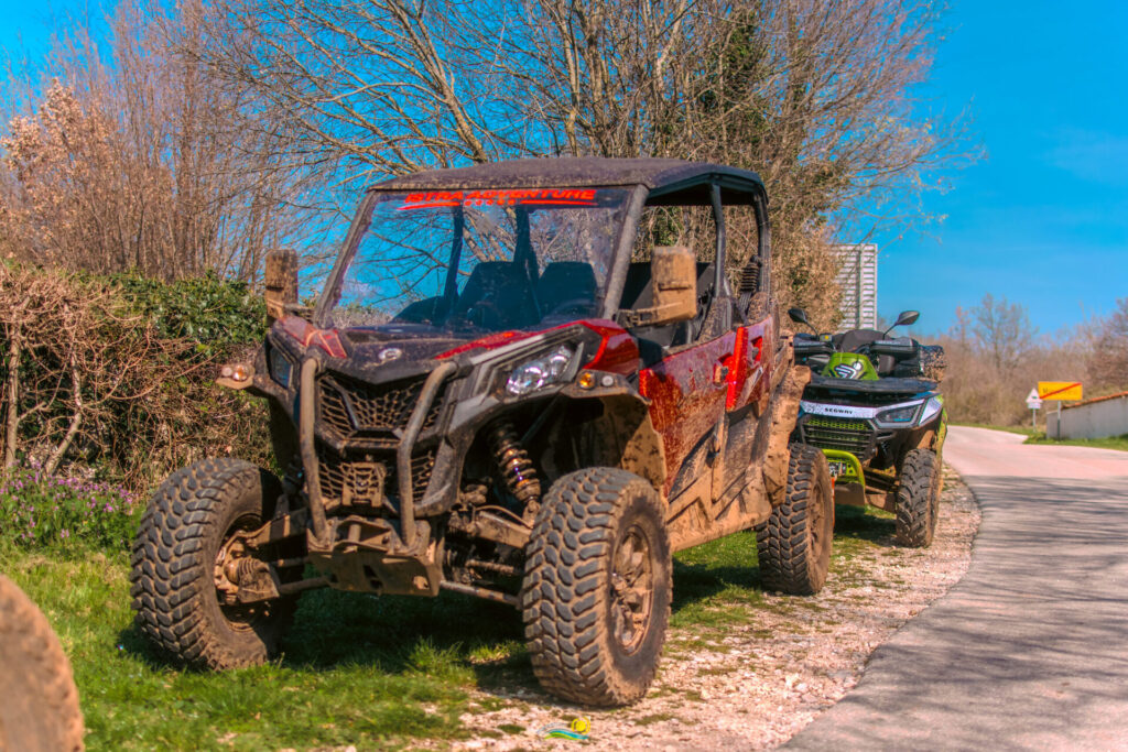 Blatnjavi buggy i quad parkirani uz seosku cestu